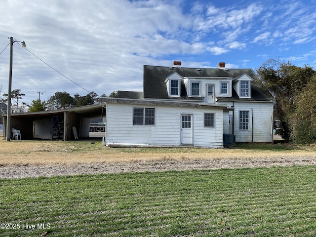 back of property with central air condition unit, a yard, and a carport