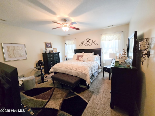 carpeted bedroom with multiple windows and ceiling fan