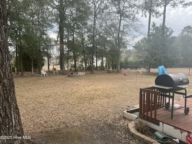 view of yard with a wooden deck and an outdoor fire pit