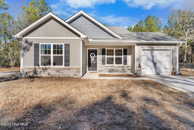 craftsman inspired home with roof with shingles, driveway, stone siding, and a garage