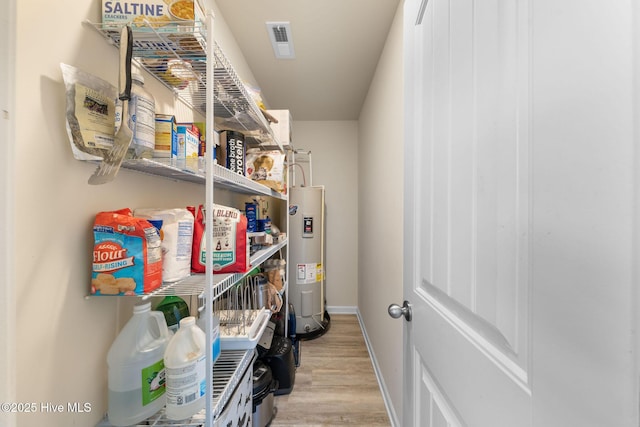 pantry with visible vents and electric water heater