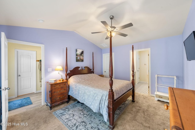 carpeted bedroom featuring ensuite bath, ceiling fan, and lofted ceiling