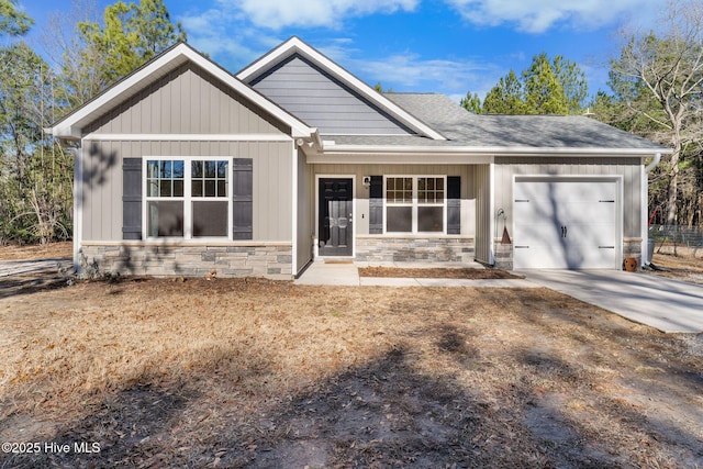 craftsman house featuring roof with shingles, driveway, stone siding, and a garage