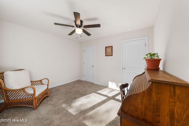 living area with carpet floors, a ceiling fan, and baseboards