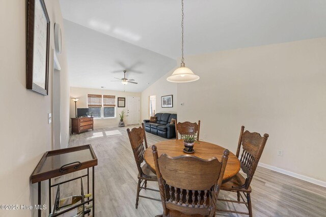 dining area with light wood-type flooring, vaulted ceiling, baseboards, and ceiling fan