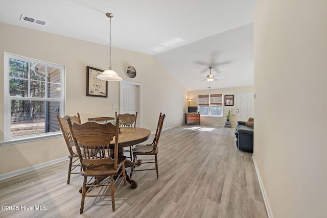 dining room featuring ceiling fan, vaulted ceiling, and light hardwood / wood-style flooring