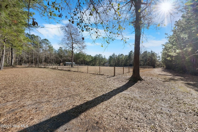 view of yard featuring fence and a view of trees