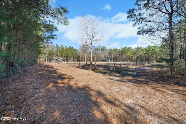 view of yard with a view of trees and fence