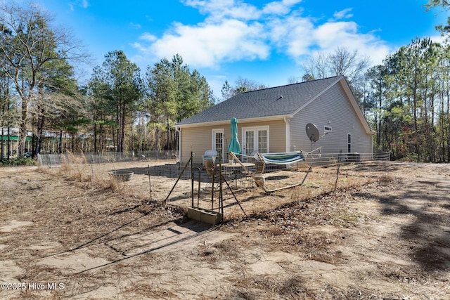 rear view of house featuring french doors and fence