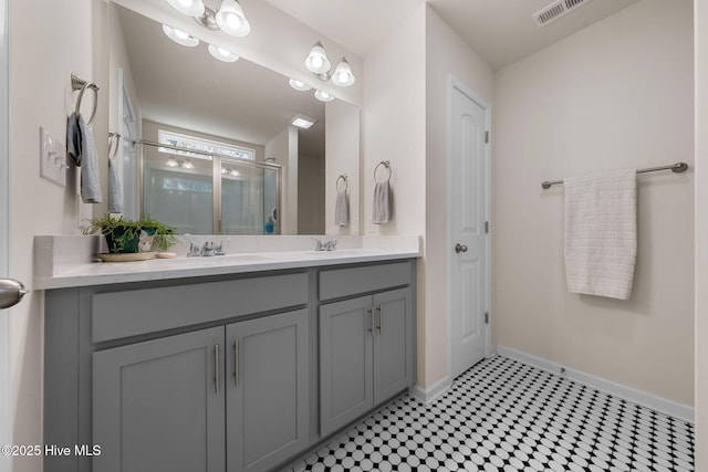 bathroom featuring tile patterned flooring, vanity, and a shower with shower door