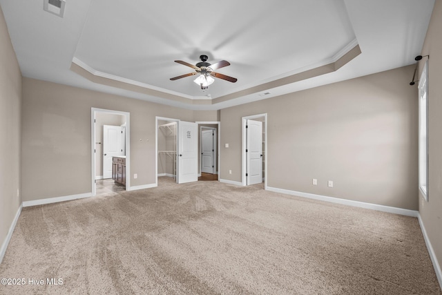 402 Kinroff Dr, Hubert, NC 28539 - unfurnished bedroom featuring a tray ceiling, carpet floors, a walk in closet, baseboards, and crown molding