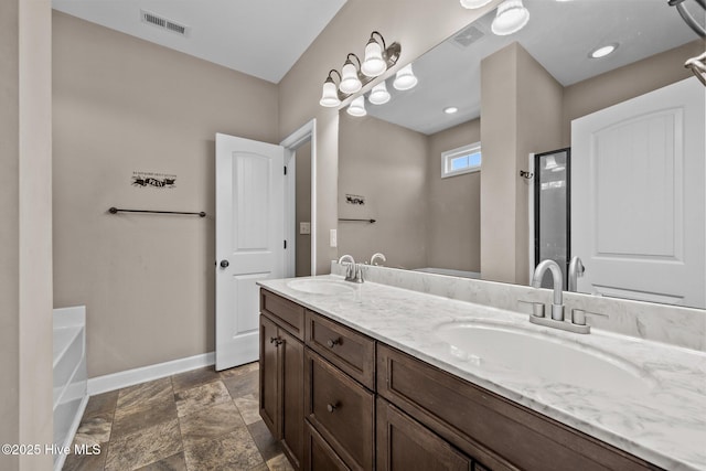 402 Kinroff Dr, Hubert, NC 28539 - bathroom with baseboards, double vanity, a garden tub, and stone finish flooring