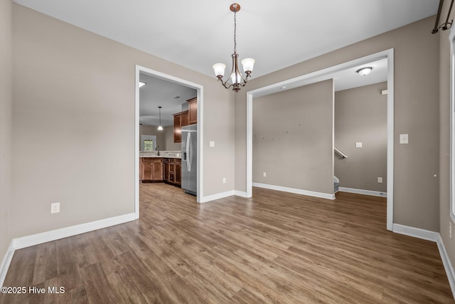 402 Kinroff Dr, Hubert, NC 28539 - empty room featuring wood finished floors, a chandelier, and baseboards