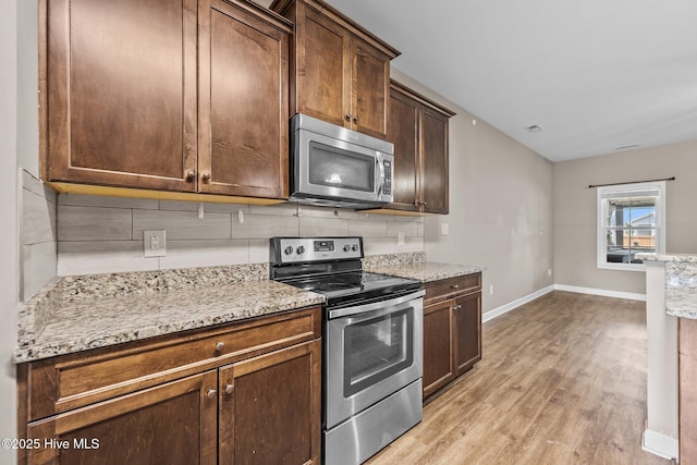 402 Kinroff Dr, Hubert, NC 28539 - kitchen featuring stainless steel refrigerator with ice dispenser, a sink, light wood-style flooring, a chandelier, and light stone counters