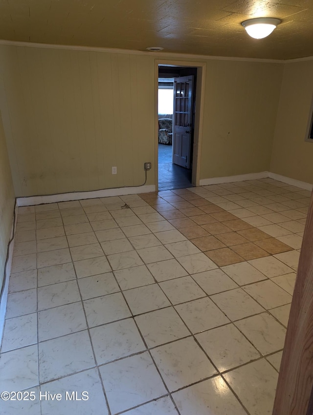 empty room featuring light tile patterned floors and crown molding