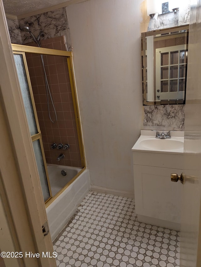 bathroom featuring sink, enclosed tub / shower combo, and a textured ceiling