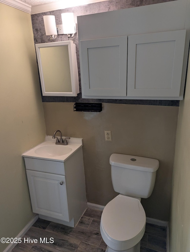 bathroom with ornamental molding, vanity, and toilet