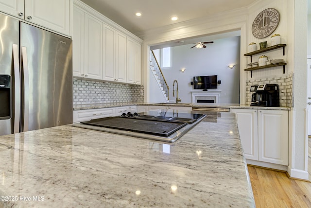 kitchen featuring light stone countertops, white cabinets, and stainless steel appliances