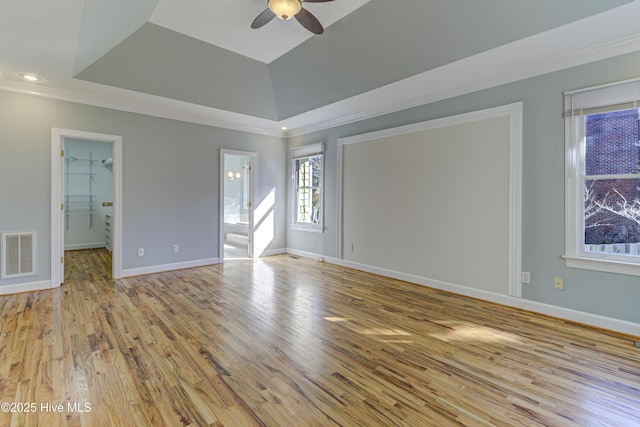 unfurnished room with ceiling fan, a tray ceiling, ornamental molding, and light hardwood / wood-style flooring