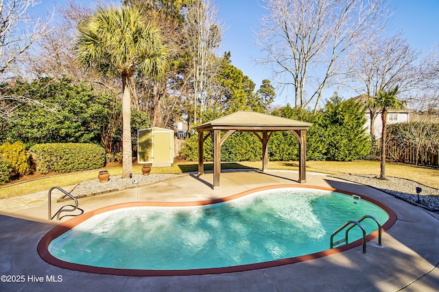 view of swimming pool featuring a shed, a gazebo, and a patio area