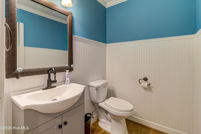 bathroom with toilet, ornamental molding, hardwood / wood-style floors, and vanity