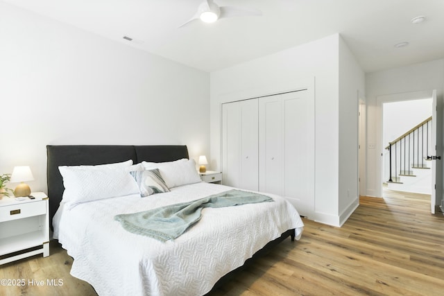 bedroom featuring hardwood / wood-style flooring, ceiling fan, and a closet