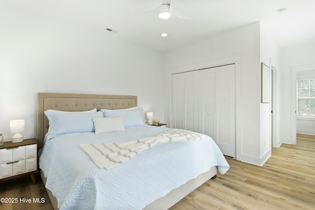 bedroom featuring ceiling fan, a closet, and light wood-type flooring