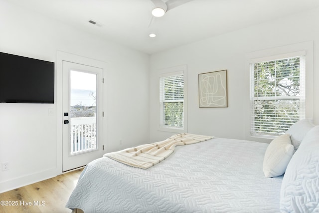 bedroom with access to exterior, multiple windows, and light wood-type flooring