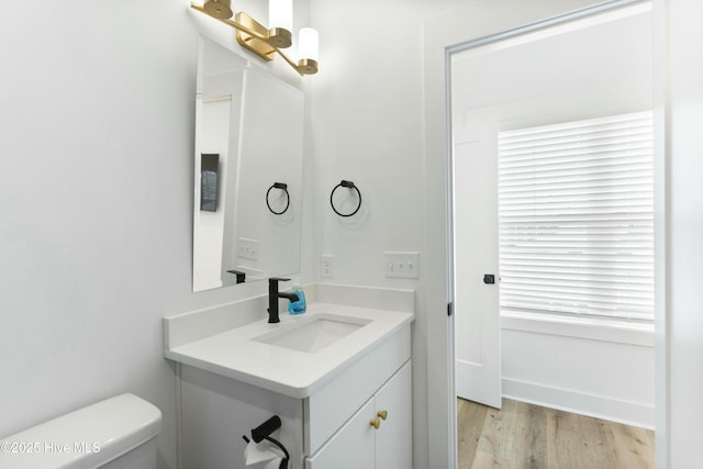 bathroom featuring vanity, hardwood / wood-style floors, and toilet