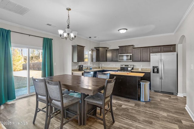 dining area featuring hardwood / wood-style floors, a notable chandelier, and ornamental molding