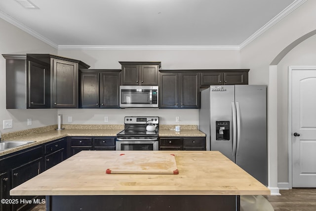 kitchen with wood counters, sink, a center island, and appliances with stainless steel finishes