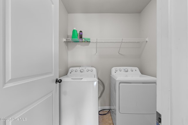 clothes washing area with light tile patterned flooring and washer and dryer