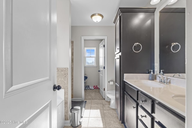 bathroom with toilet, tile patterned flooring, and vanity