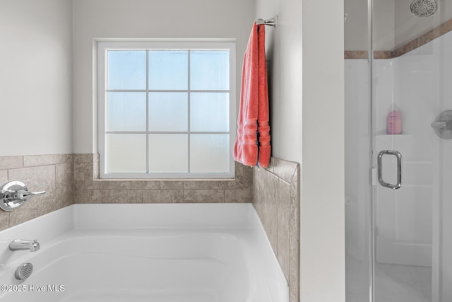 bathroom featuring a healthy amount of sunlight and shower with separate bathtub