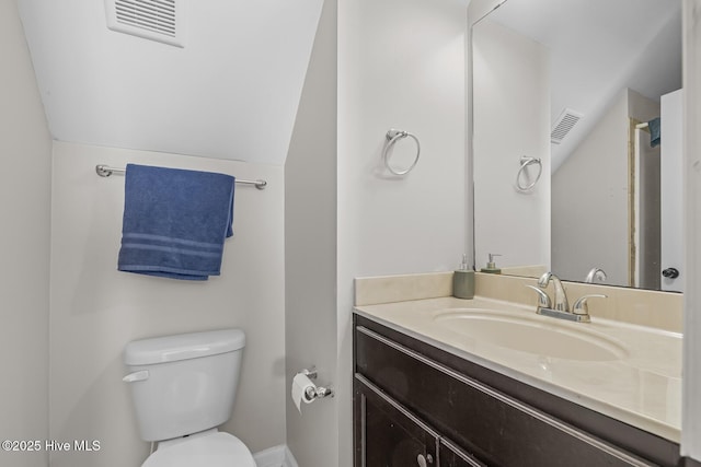 bathroom with vanity, toilet, and lofted ceiling