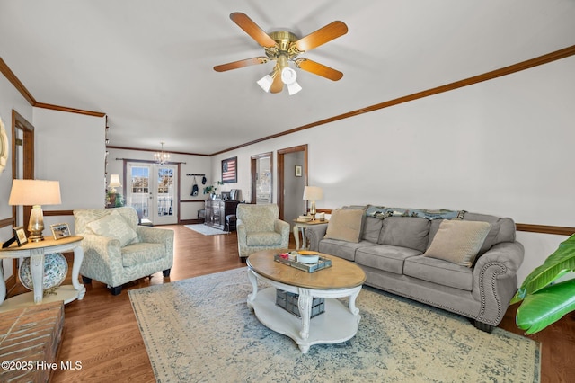 living room with crown molding, french doors, ceiling fan with notable chandelier, and hardwood / wood-style flooring