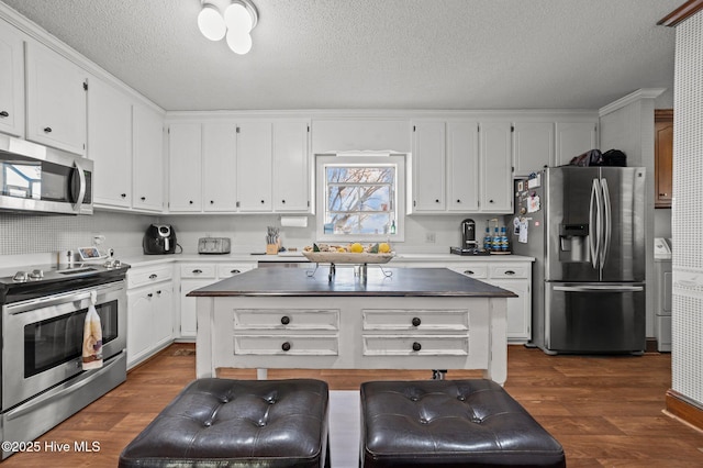 kitchen with dark hardwood / wood-style floors, white cabinetry, and appliances with stainless steel finishes