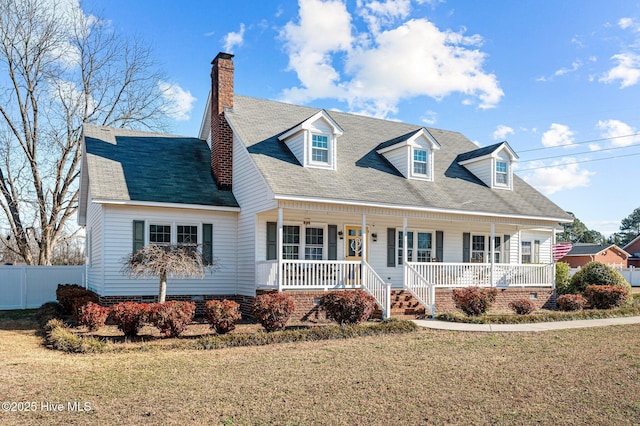 cape cod-style house with covered porch and a front yard