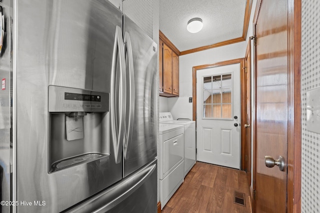 laundry area with cabinets, crown molding, a textured ceiling, dark hardwood / wood-style flooring, and washing machine and clothes dryer