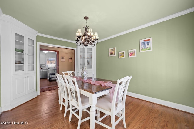 dining room featuring dark hardwood / wood-style flooring, an inviting chandelier, and ornamental molding