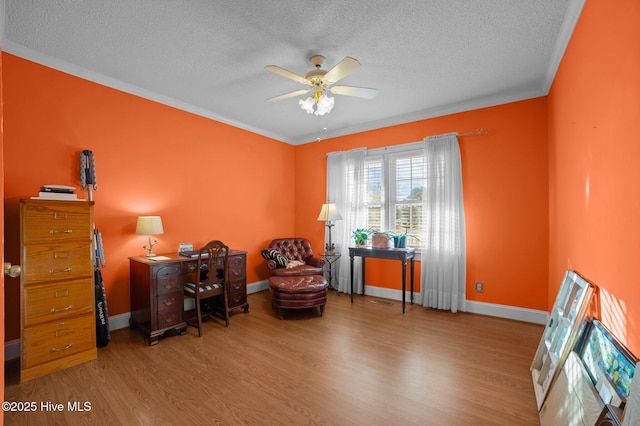 sitting room with ceiling fan, light hardwood / wood-style floors, a textured ceiling, and ornamental molding