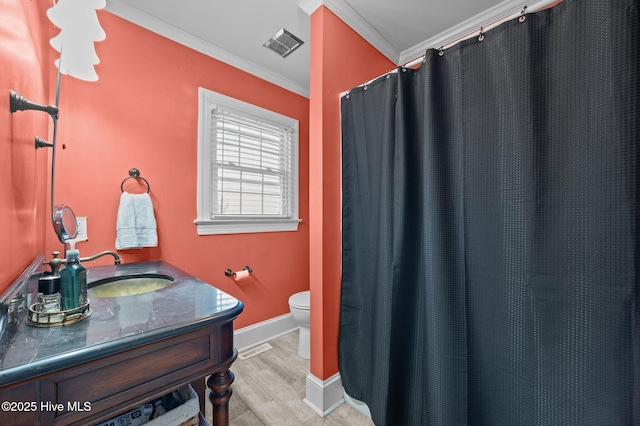 bathroom featuring wood-type flooring, vanity, toilet, and ornamental molding