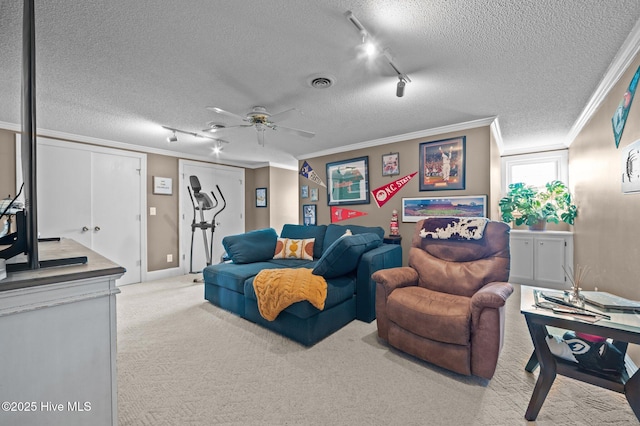 carpeted living room featuring ceiling fan, ornamental molding, a textured ceiling, and track lighting