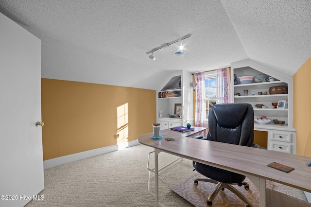 carpeted office with a textured ceiling, built in features, and vaulted ceiling