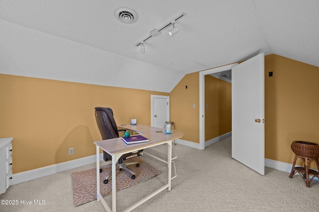 carpeted home office with a textured ceiling and vaulted ceiling