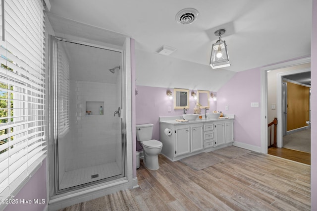 bathroom with an enclosed shower, toilet, vaulted ceiling, vanity, and hardwood / wood-style flooring