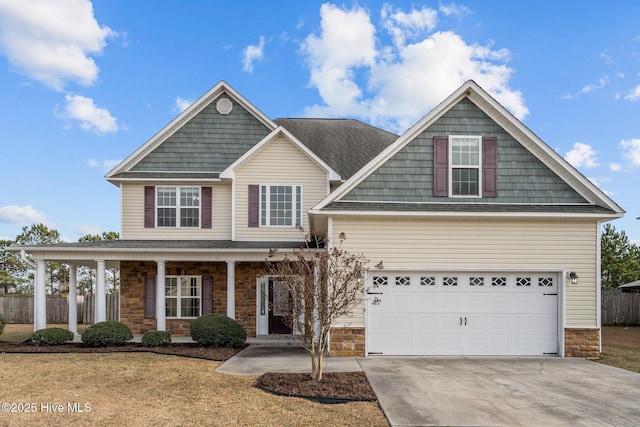 view of front of property featuring a garage, a front yard, and covered porch