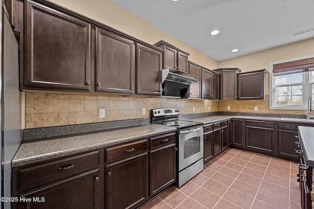 kitchen featuring appliances with stainless steel finishes, decorative backsplash, exhaust hood, light tile patterned floors, and dark brown cabinets