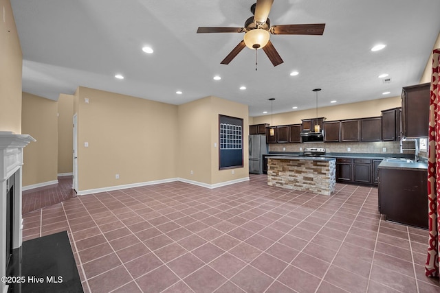 kitchen featuring sink, backsplash, hanging light fixtures, a center island, and stainless steel appliances