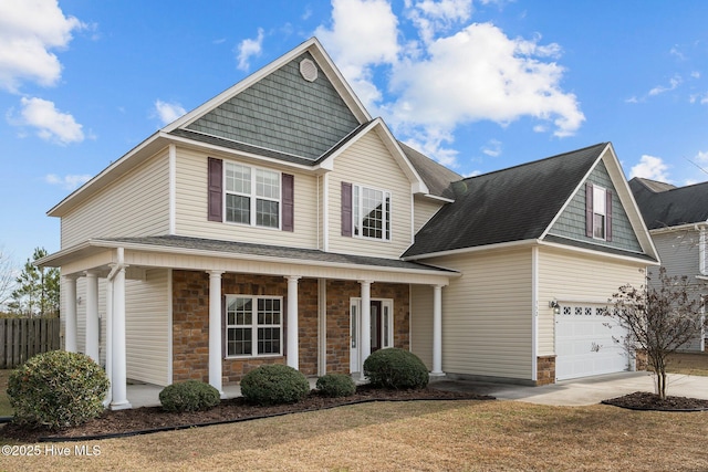 view of front facade with covered porch, a front lawn, and a garage